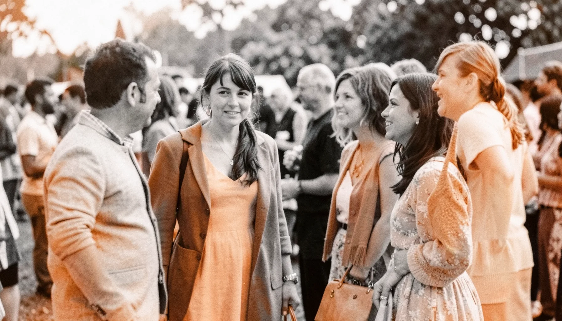 Black and white photograph of a group standing together outdoors at a community event, warm and informal in feeling
