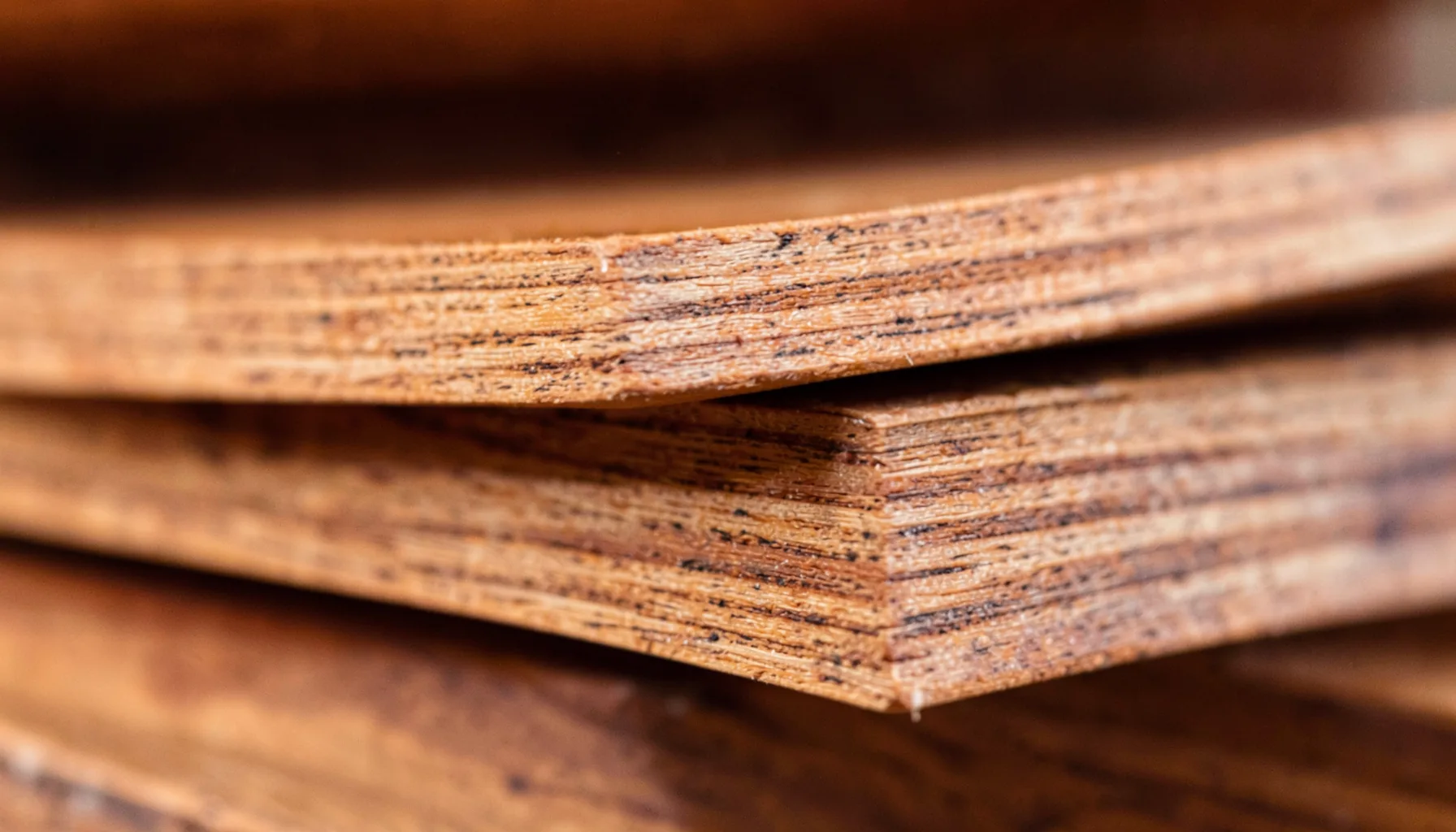 Close-up of stacked wooden shelving grain in warm brown and tan tones, sturdy and grounded in mood